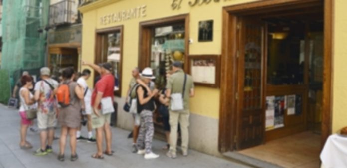 El excelente puente de la Virgen evidencia un buen verano para el sector turístico Un grupo de turistas consulta la oferta gastronómica de uno de los restaurantes de la capital segoviana. / Cristina Yusta