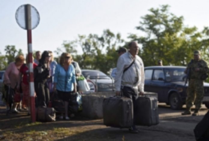 Lugansk inicia la retirada de parte de su armamento de la línea divisoria ucraniana Varias personas cruzan el puesto de control de Zaytsevo en Ucrania. / EFE
