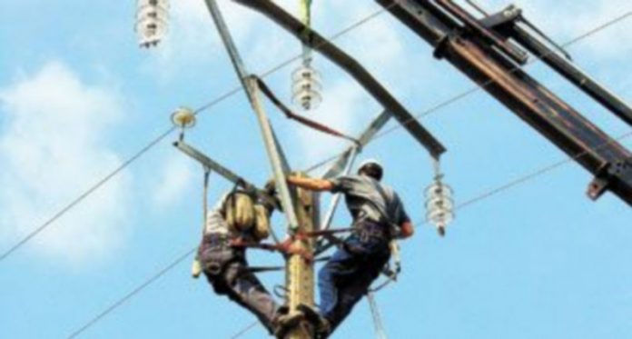 El consumo eléctrico baja un 4 Dos operarios de la energía arreglan una torre de alta tensión.