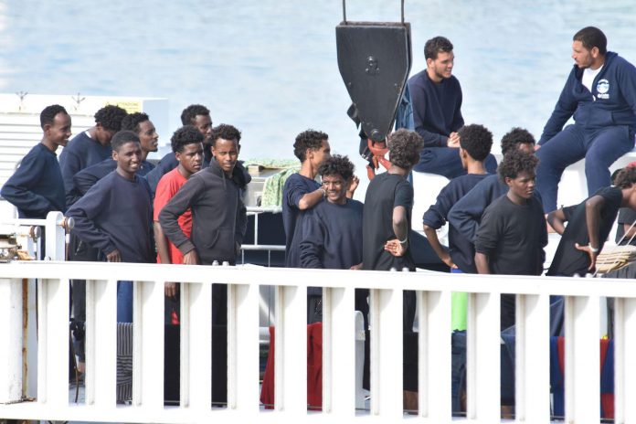 Los 148 inmigrantes que siguen a bordo del barco militar Varios migrantes aguardan a bordo de barco de los guardacostas