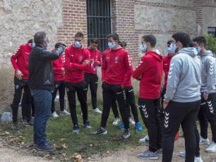 Los jugadores de a Segoviana conversan con el jefe de prensa del club, Javier de Andrés. / KAMARERO