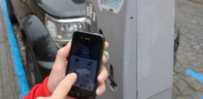 Una usuaria muestra la aplicación descargada en su teléfono y que hará innecesario el uso del parquímetro. / Kamarero