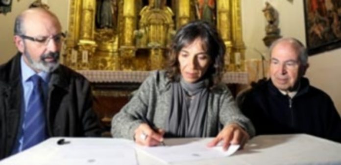 María Martín apoya la declaración de Interés Turístico Nacional de la Semana Santa Martín estampa su firma en presencia del presidente de la Junta de Cofradías y del párroco de Santo Tomás./ Kamarero