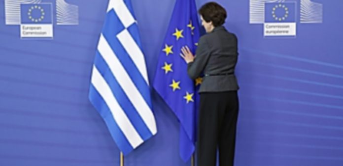 Las negociaciones sobre el rescate de Grecia podrían retomarse hoy Una mujer arregla las banderas de Grecia y la Unión Europea en la sede de la UE en Bélgica