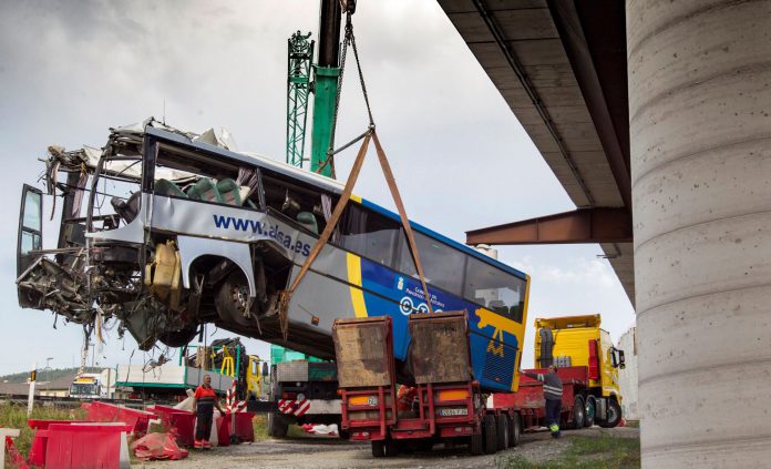Accidente de autobús en Avilés Una grúa retira los restos del autobús de la compañía ALSA que se empotró contra la pilastra de hormigón.