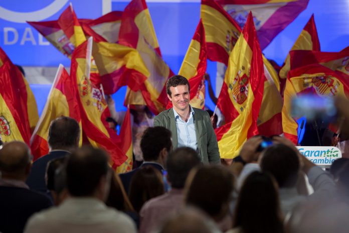 Pablo Casado El presidente del PP, Pablo Casado, envuelto en banderas de España durante el acto organizado en Málaga con motivo de la Fiesta Nacional.