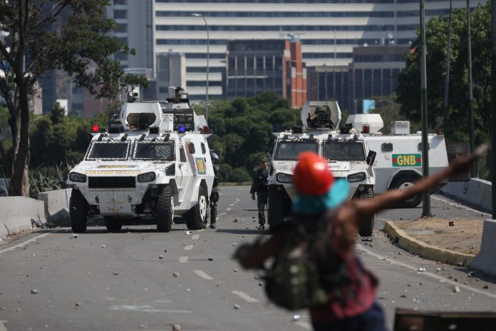 Oposición en Caracas apoya el levantamiento del presidente de la Asamblea Nacional, Juan Guaidó La Guardia Nacional Bolivariana intenta controlar a los manifestantes.